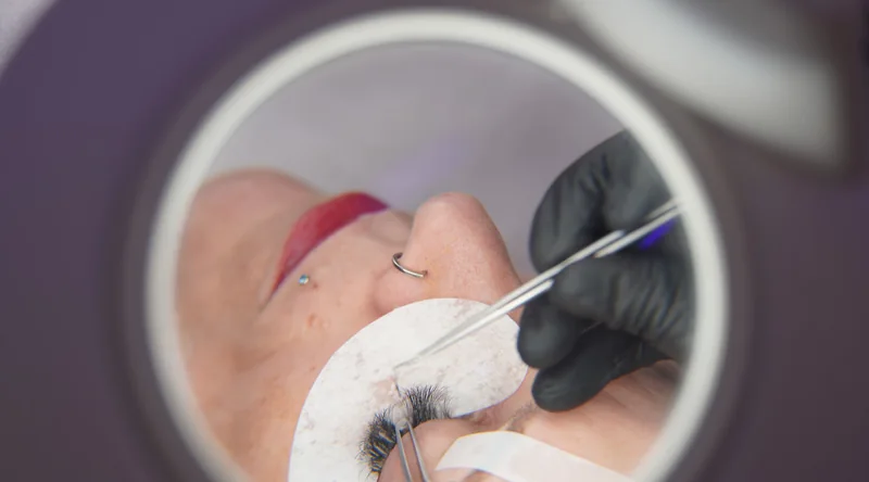 View through a magnifying lamp while individual eyelashes are isolated in the Lucerne salon