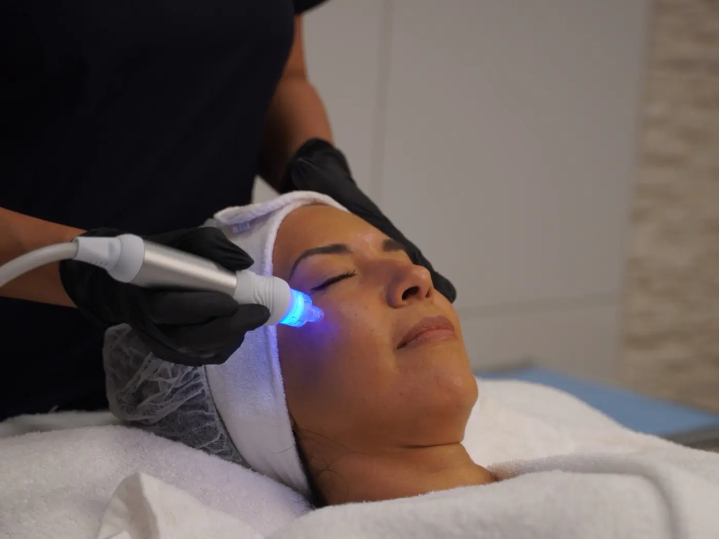 HydraFacial im Beauty Rocío Luzern: der blau leuchtende Aufsatz auf der Wange einer Kundin