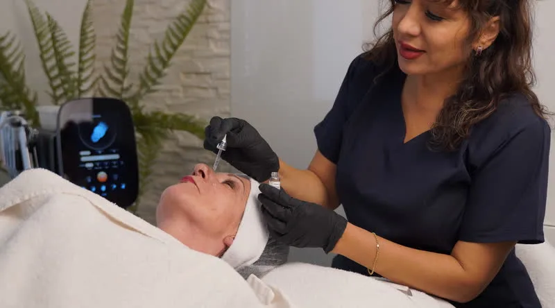 Rocío Furger trägt nach der Behandlung mit der Pipette ein Serum auf die Haut auf